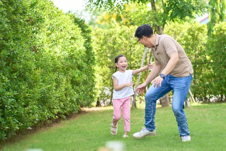 dad and daughter running and playing outside